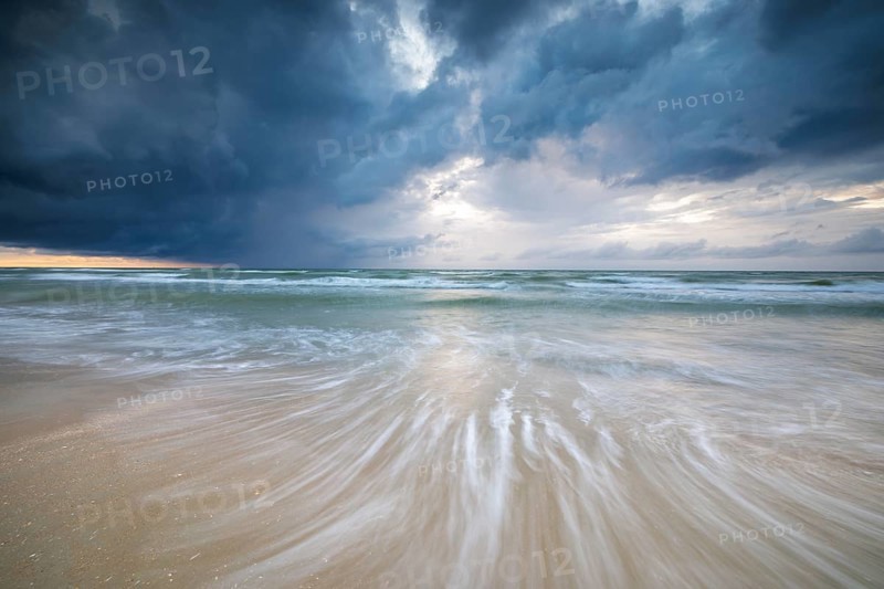 Evening mood with cloudy sky and rain on the beach and in the dunes of De Panne
