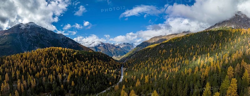Colourful autumn landscape with a view of the Swiss National Park and the Lai dad Ova Spin reservoir