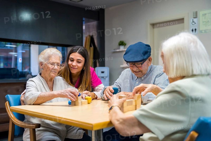 Elderly people and a nurse in a nursing home sharing skills games