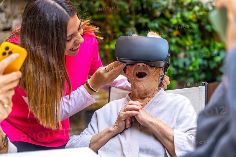 Nurse and amazed senior woman using Virtual Reality goggles in a geriatric