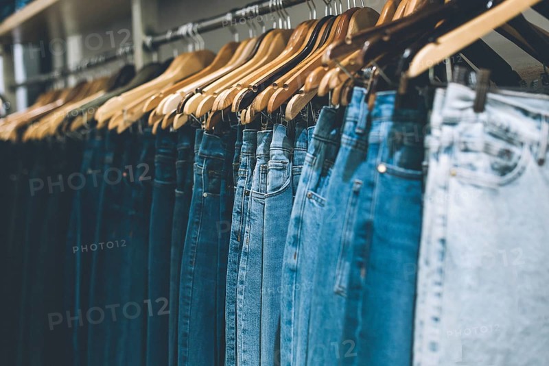 Jeans hanging on a rack in a store. Copy space