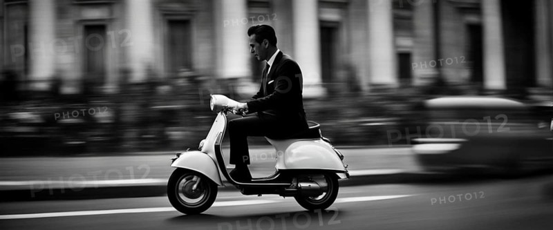 Italian elegant man wearing suit and tie driving moped vintage scooter in Rome Italy at sunset traditional urban scene