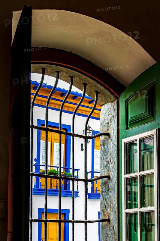 Historic colonial style house seen through the window of a church in the city of Mariana in the state of Minas Gerais