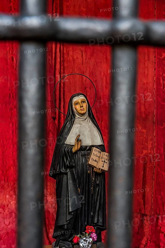 Model of a praying nun behind bars