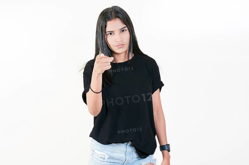 Young girl pointing at you frowning isolated. Serious girl pointing at the camera