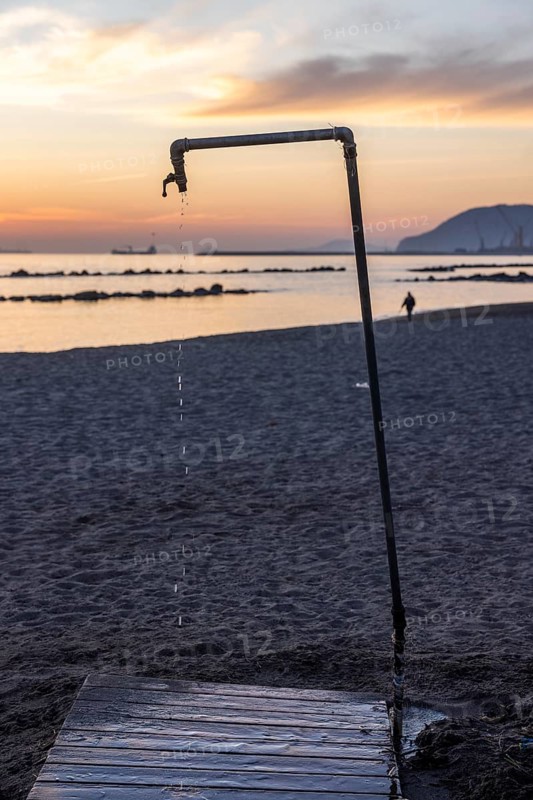 Dripping shower at sunset on the beach