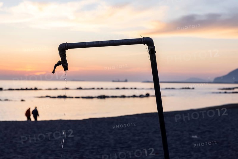 Dripping shower at sunset on the beach