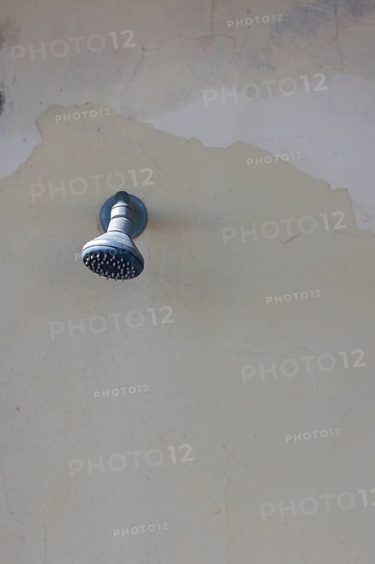 Shower on a weathered wall on the beach