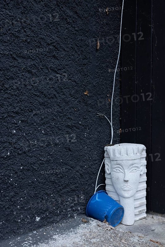 Bizarre still life with a sphinx from the hardware store and a blue bucket