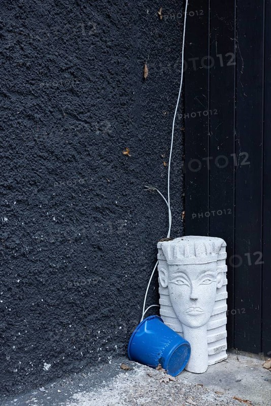 Bizarre still life with a sphinx from the hardware store and a blue bucket