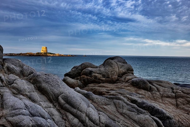 Bizarre rock formations on the beach in front of the Torre di Bari Sardo in the evening light