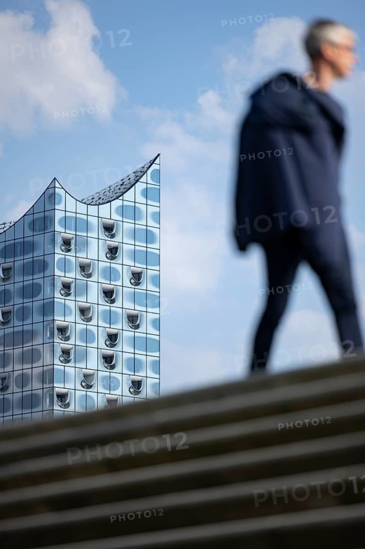 Silhouettes of people on the harbour promenade in front of the Elbe Philharmonic Hall