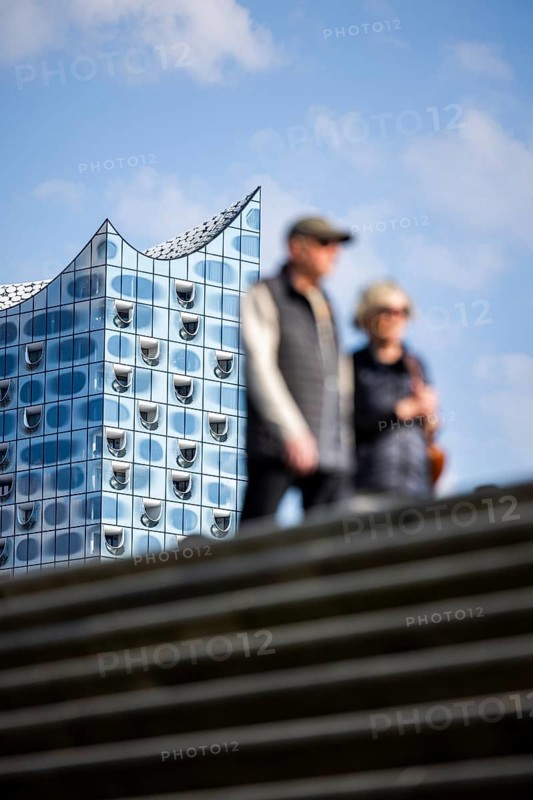 Silhouettes of people on the harbour promenade in front of the Elbe Philharmonic Hall