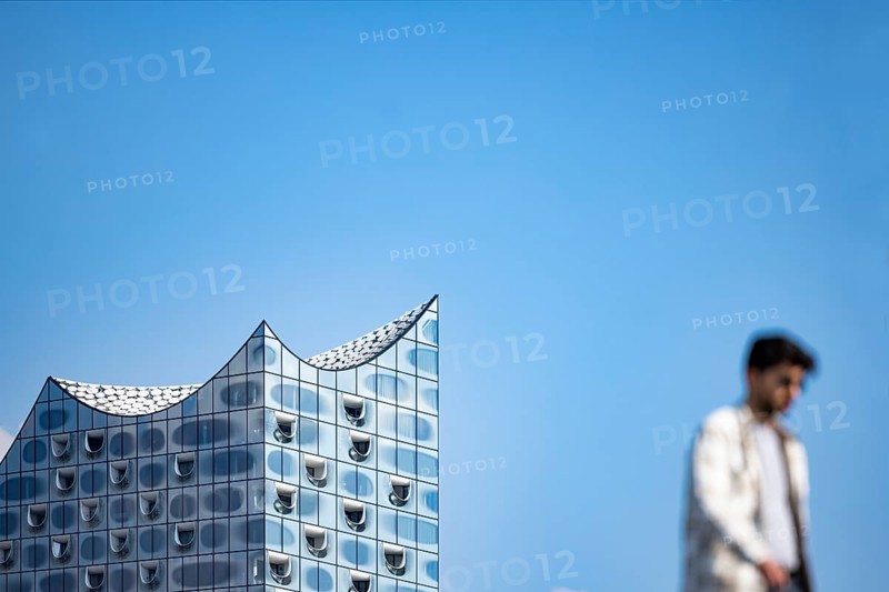 Silhouettes of people on the harbour promenade in front of the Elbe Philharmonic Hall
