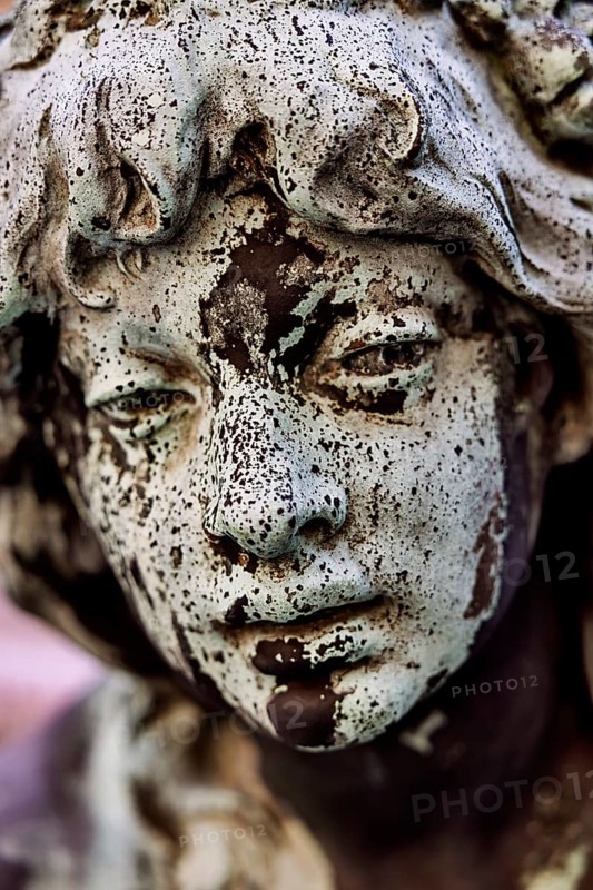 Weathered face of a figure at the Hygieia fountain in the town hall courtyard