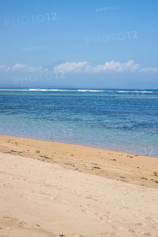 Sunrise on the sandy beach. Landscape shot with a view of the sea and the beach. Waves of light and a morning atmosphere that only exists in Sanur