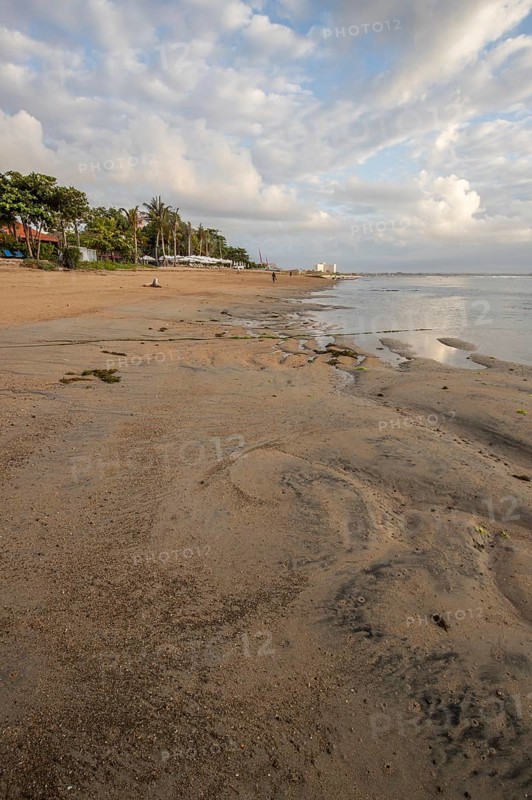 Sunrise on the sandy beach. Landscape shot with a view of the sea and the beach. Waves of light and a morning atmosphere that only exists in Sanur