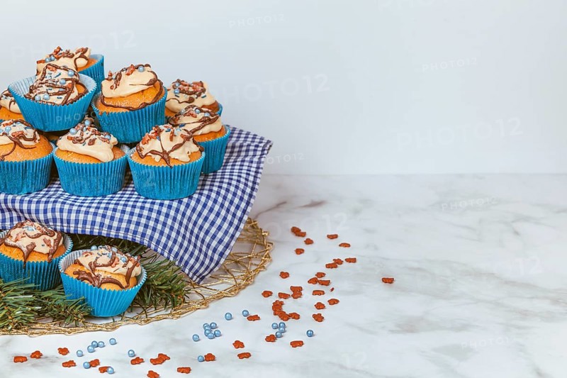 Cupcakes in blue ramekins with chocolate icing and sugar sprinkles