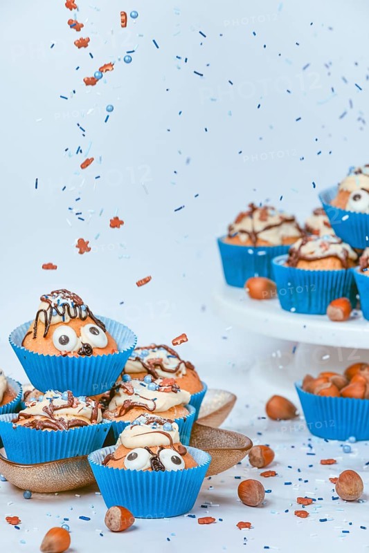 Cupcakes in blue ramekins with chocolate icing and sugar sprinkles