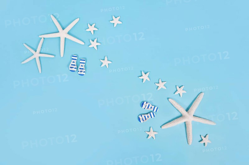 Simple summer banner with white starfish and sandals on blue background