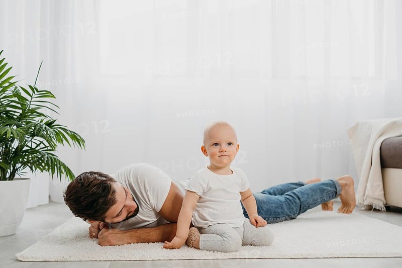 Baby standing floor home with father