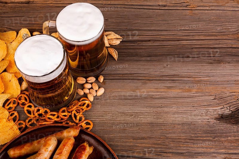 Close up beer with snacks wooden table