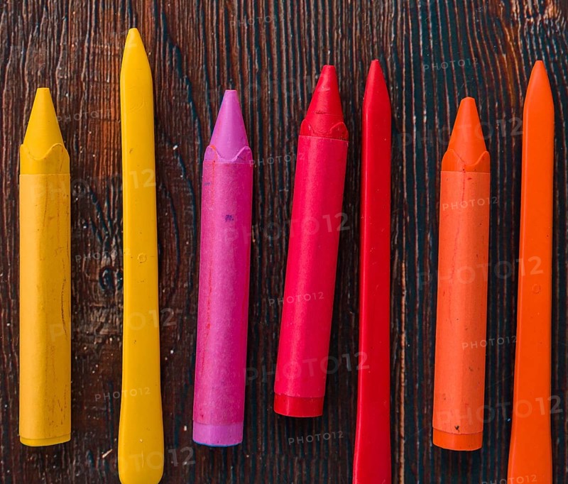 Close up colorful wax crayons wooden textured plank