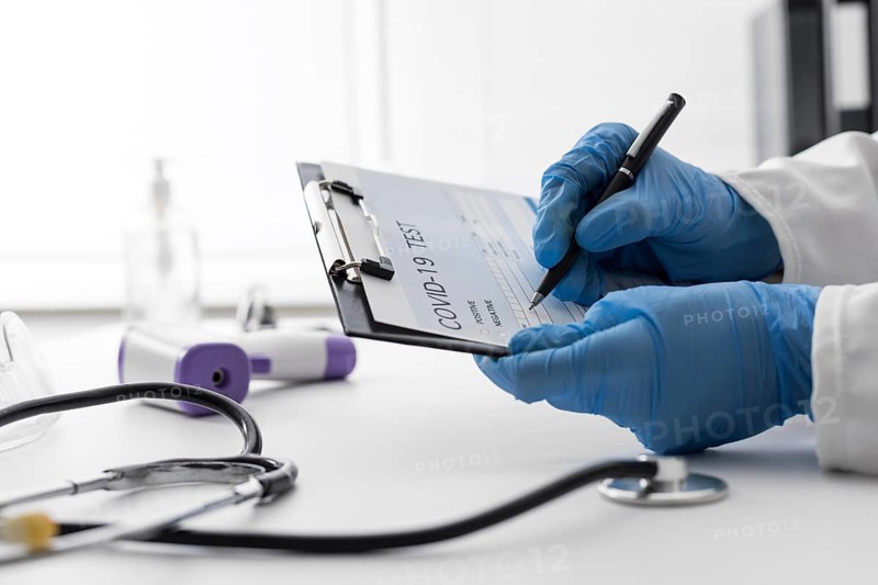 Close up doctor filling covid medical form