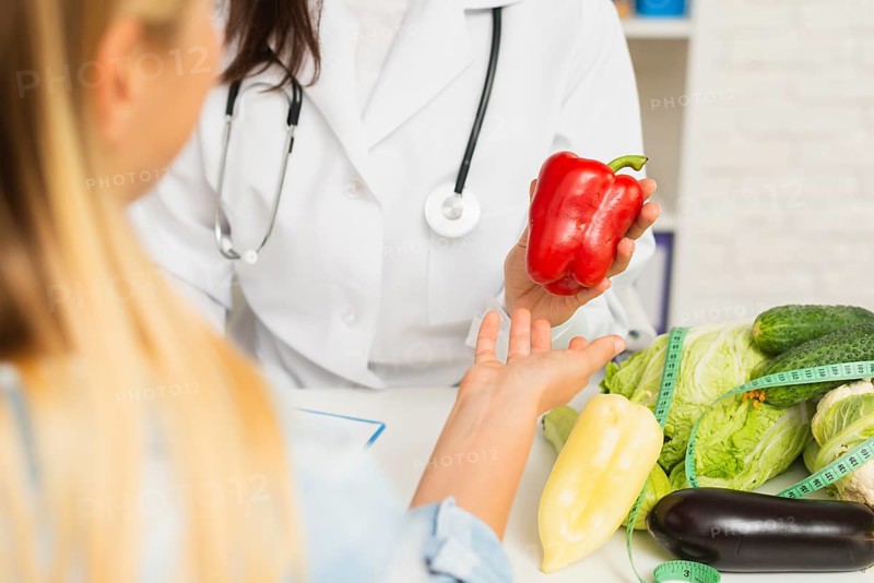 Close up doctor patient with vegetables