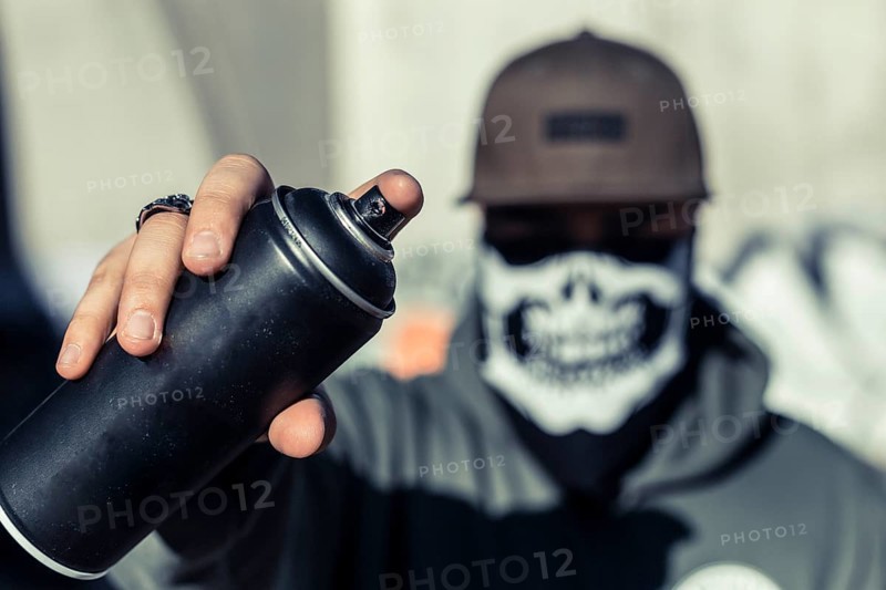 Close up man s hand holding black aerosol can