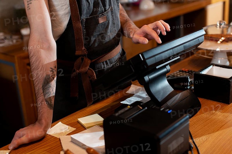Close up man working cash register