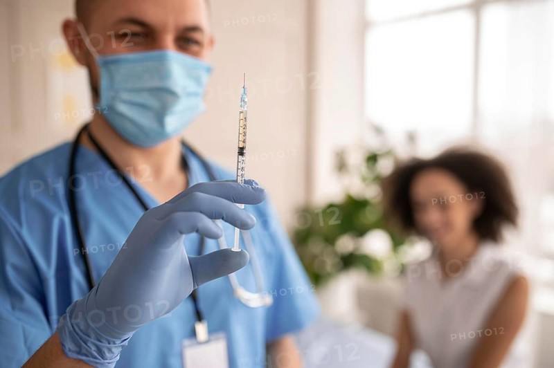 Doctor holding syringe with vaccine patient