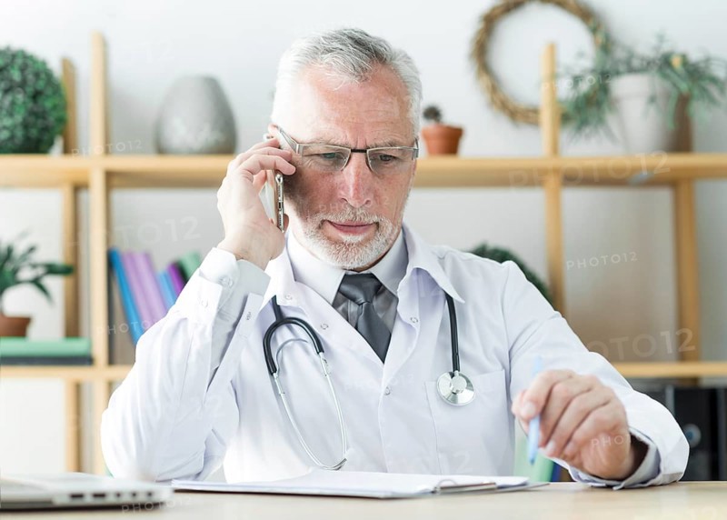 Doctor speaking phone office