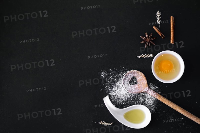 Elevated view egg spices grain heart shape spoon flour oil black surface