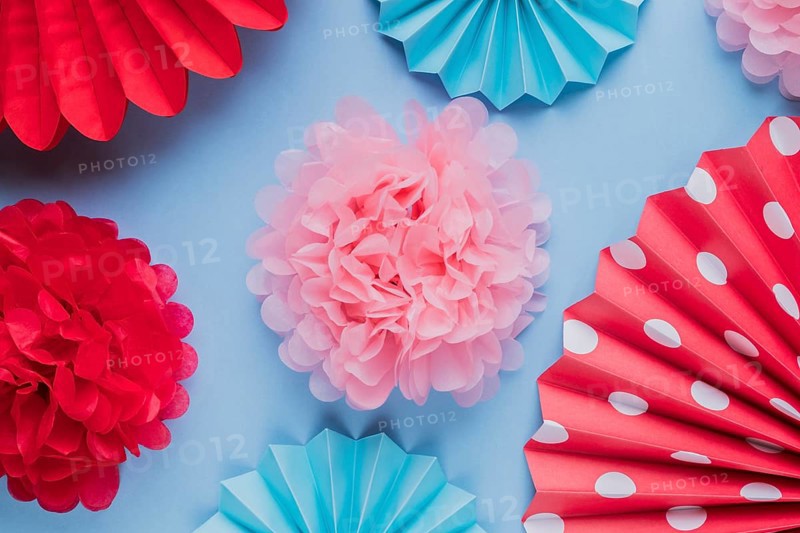 Fake beautiful decorative origami paper flowers blue surface