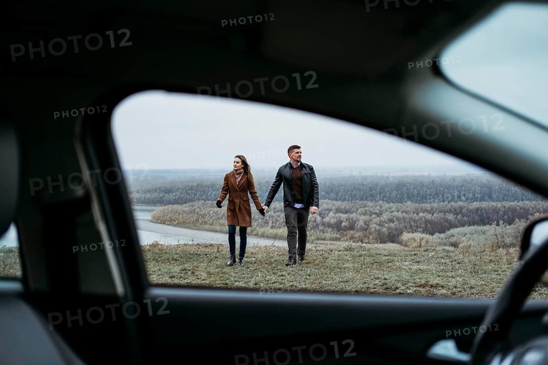 Front view couple holding hands from inside car