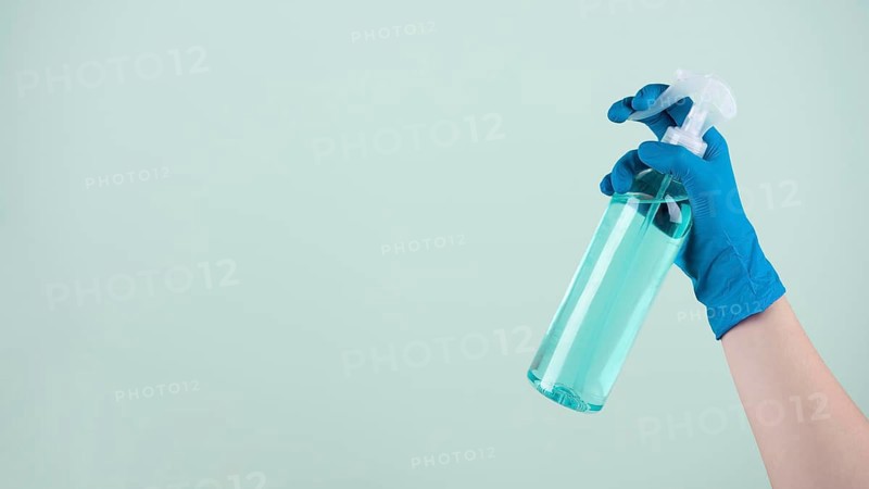 Front view hand with surgical glove holding disinfectant