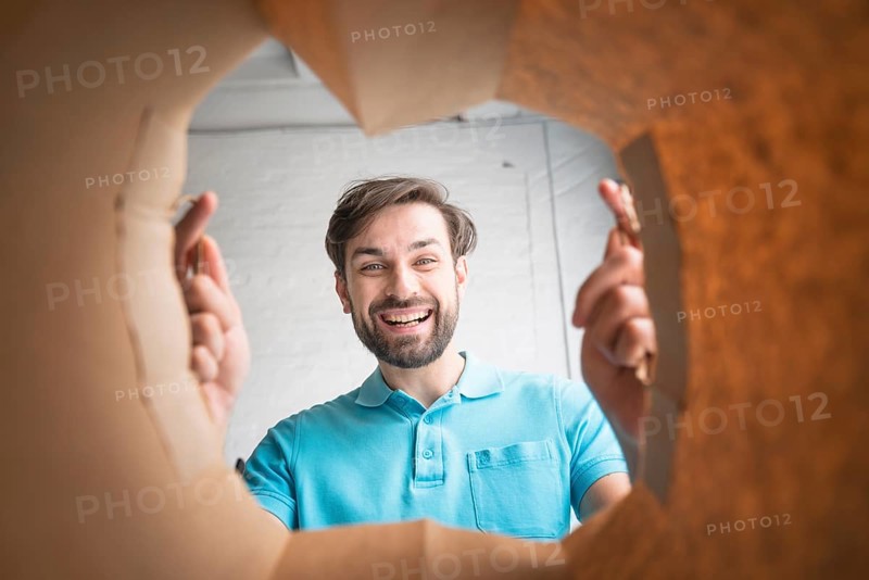 Happy man looking inside paper bag