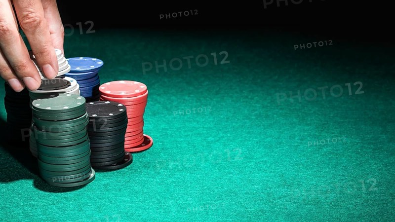 Human hand with casino chips green table