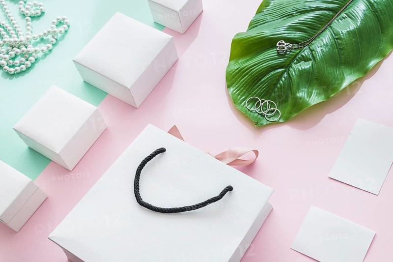Jewelry with white boxes leaf paper backdrop