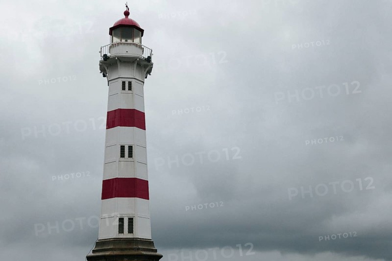 Lighthouse against dark overcast sky