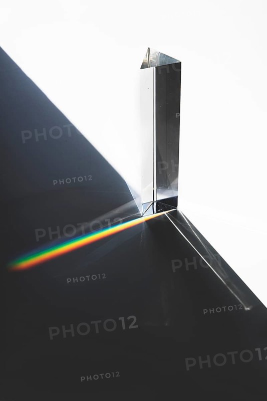 Light passing through triangular prism with dark shadow white surface