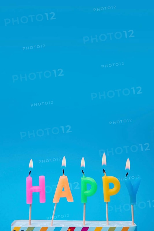Lit colorful candles with blue background
