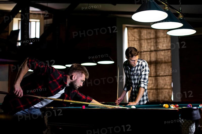 Low angle guys playing billiard club