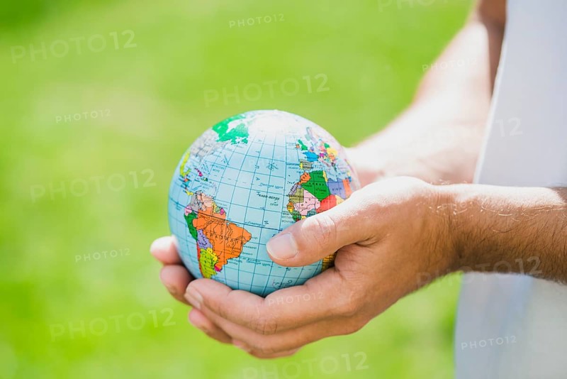 Man s hand holding small globe