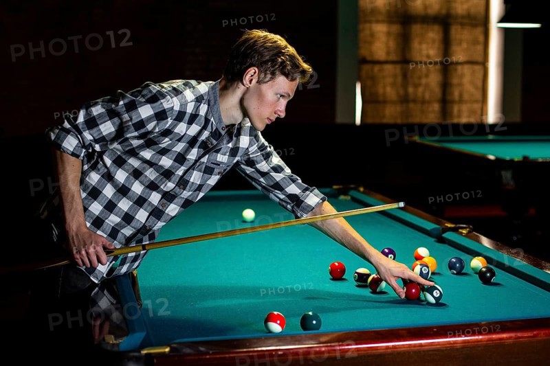 Medium shot man holding pool cue ball