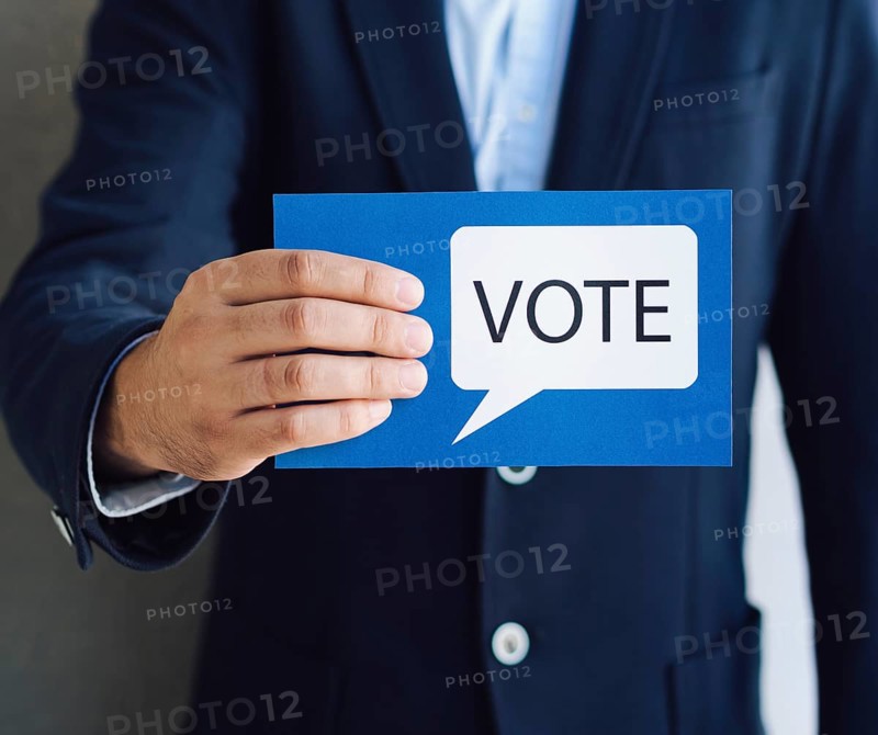 Medium shot man showing voting card with speech bubble