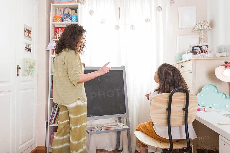 Mother tutoring girl home