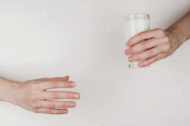 Person handing glass milk another one