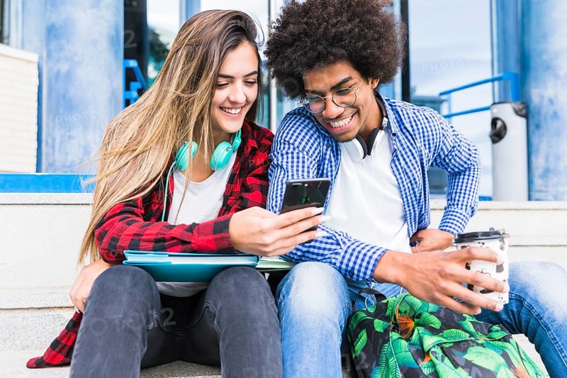 Portrait smiling diverse young students looking mobile phone